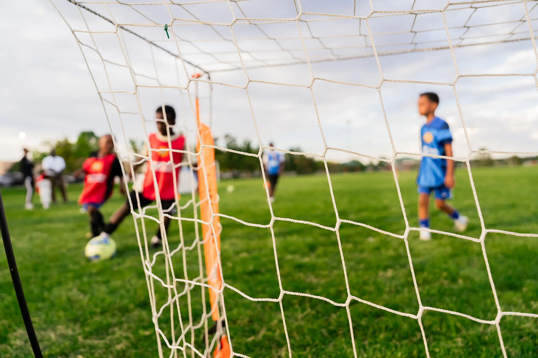 Children playing soccer on grass field