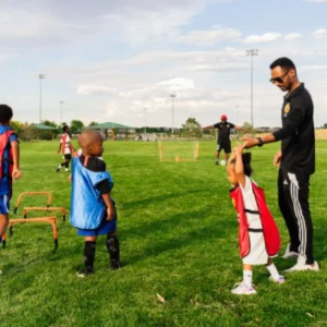 Coach guiding young soccer players